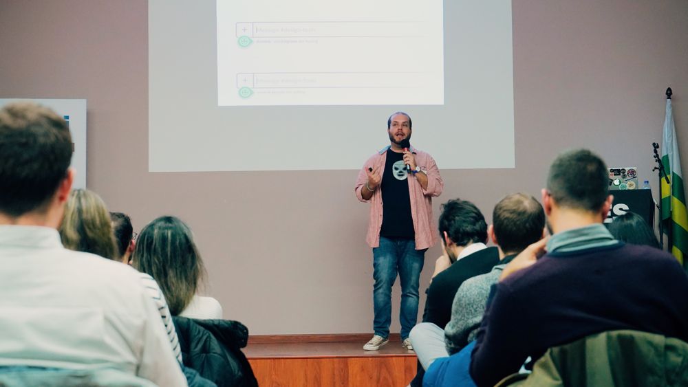 Mario speaking on stage in a lucha libre mask t-shirt